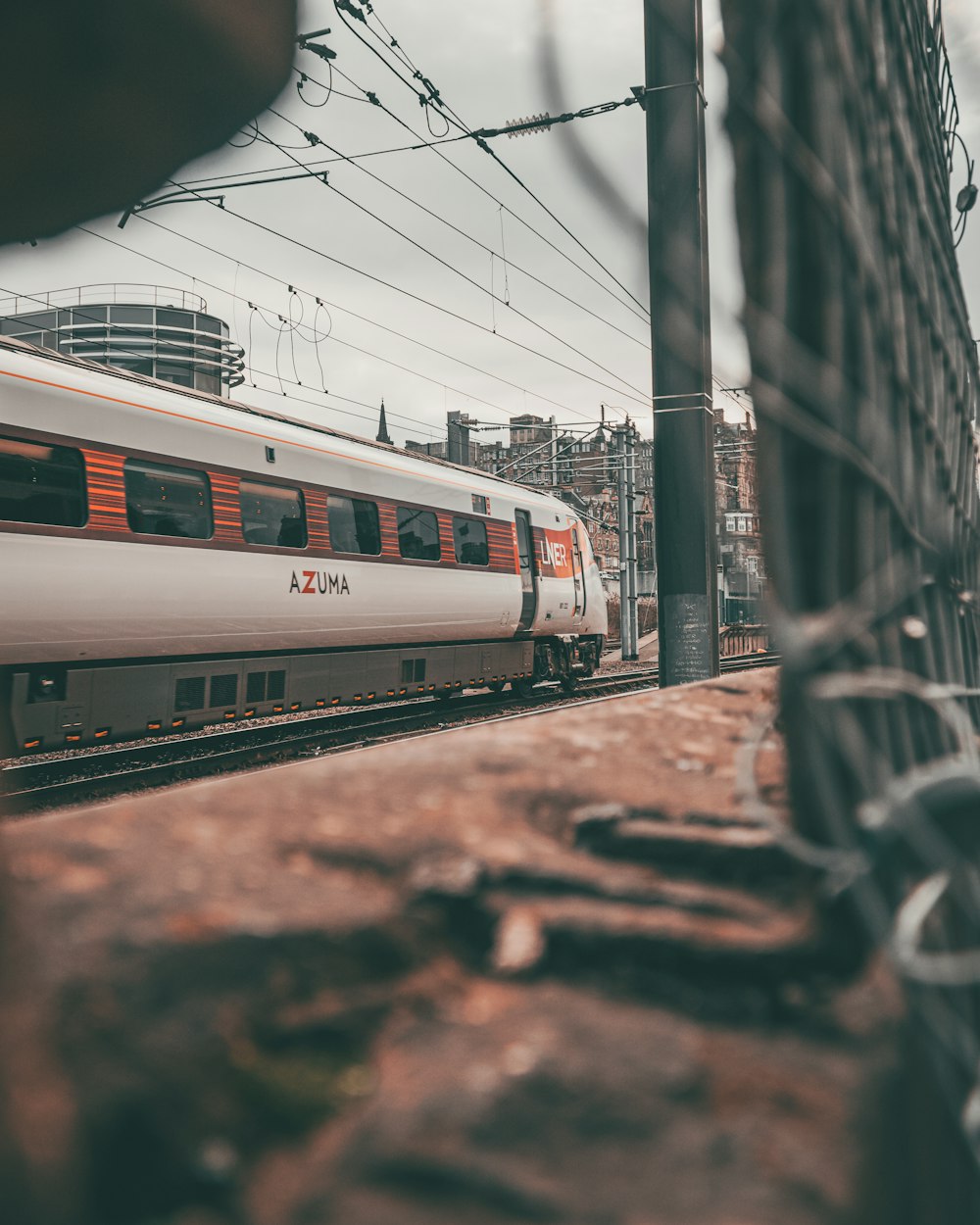 a train traveling down train tracks next to a tall building