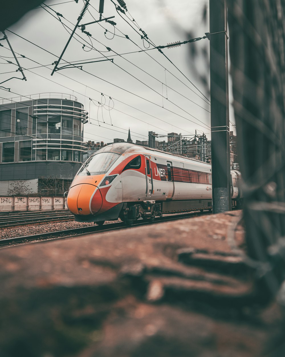 a white and orange train traveling down train tracks