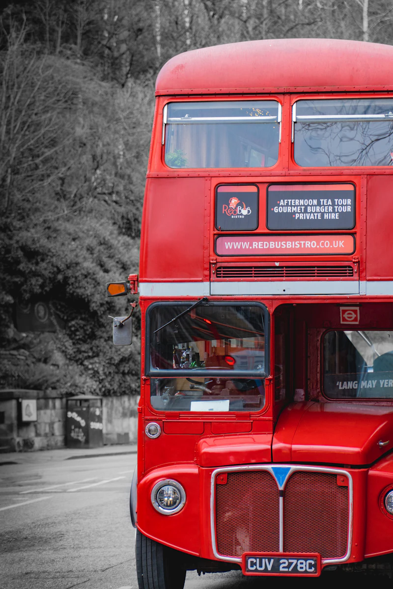 Red double decker bus driving through a city street representing group travel