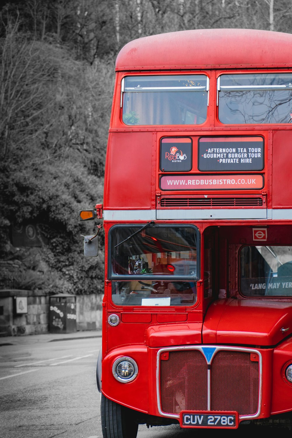 a red double decker bus driving down a street