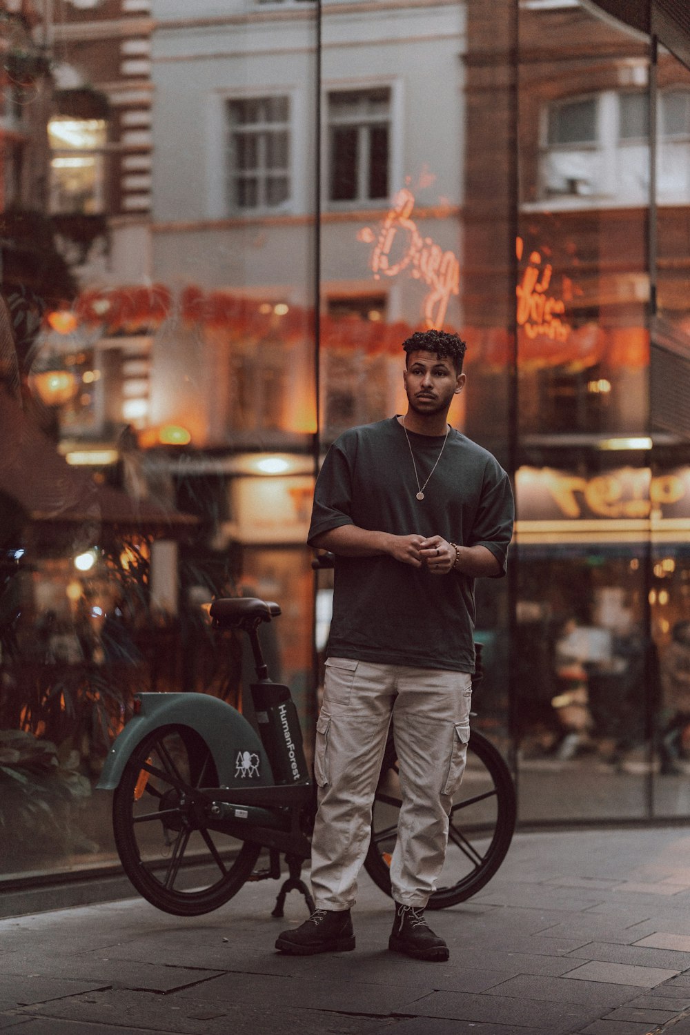 a man standing next to a bike on a city street