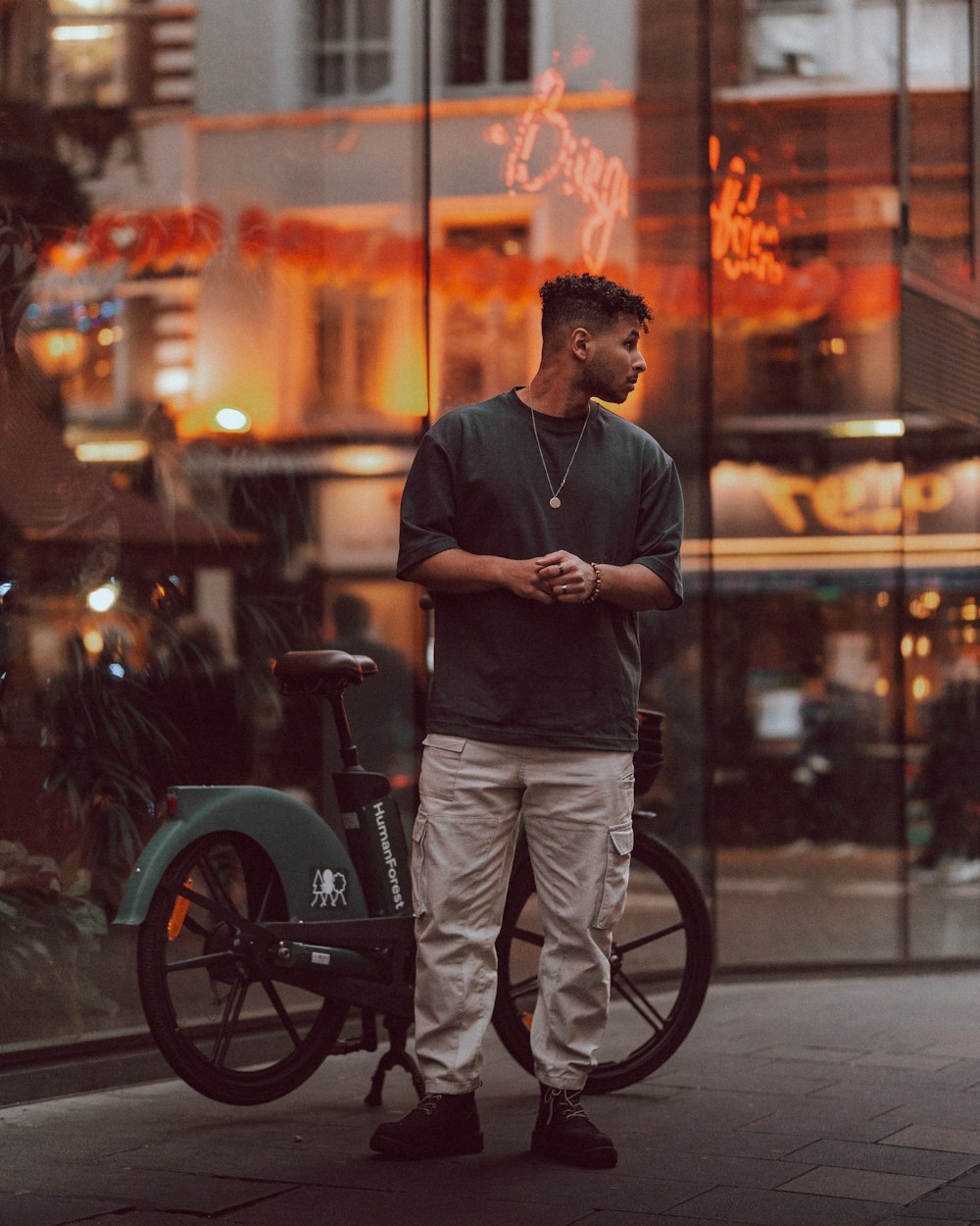 a man standing next to a bike on a city street