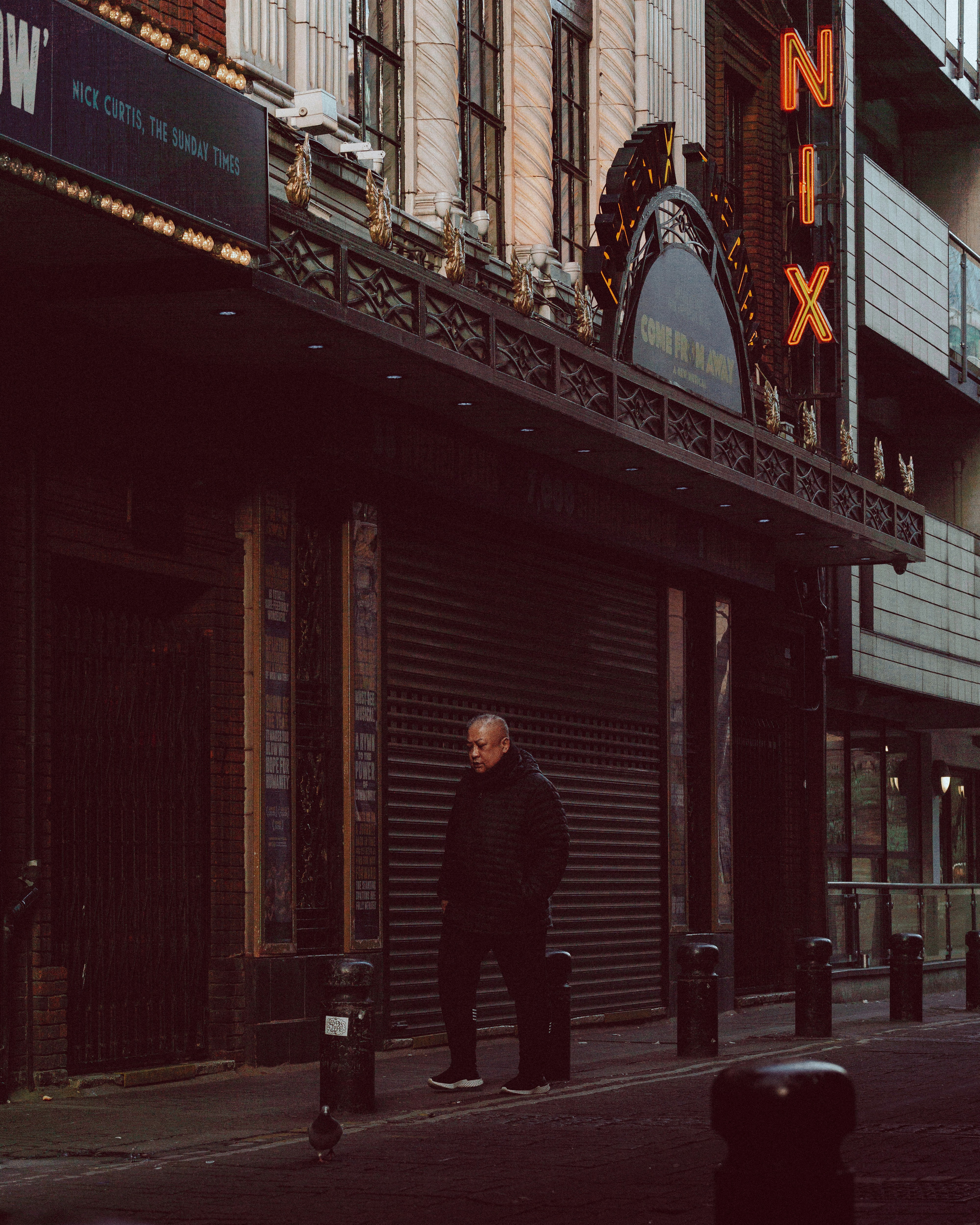Man wearing a black shell coat in an urban setting