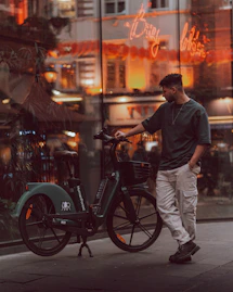 a man standing next to a bike on a city street