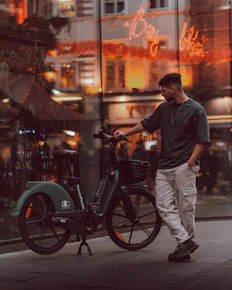 a man standing next to a bike on a city street
