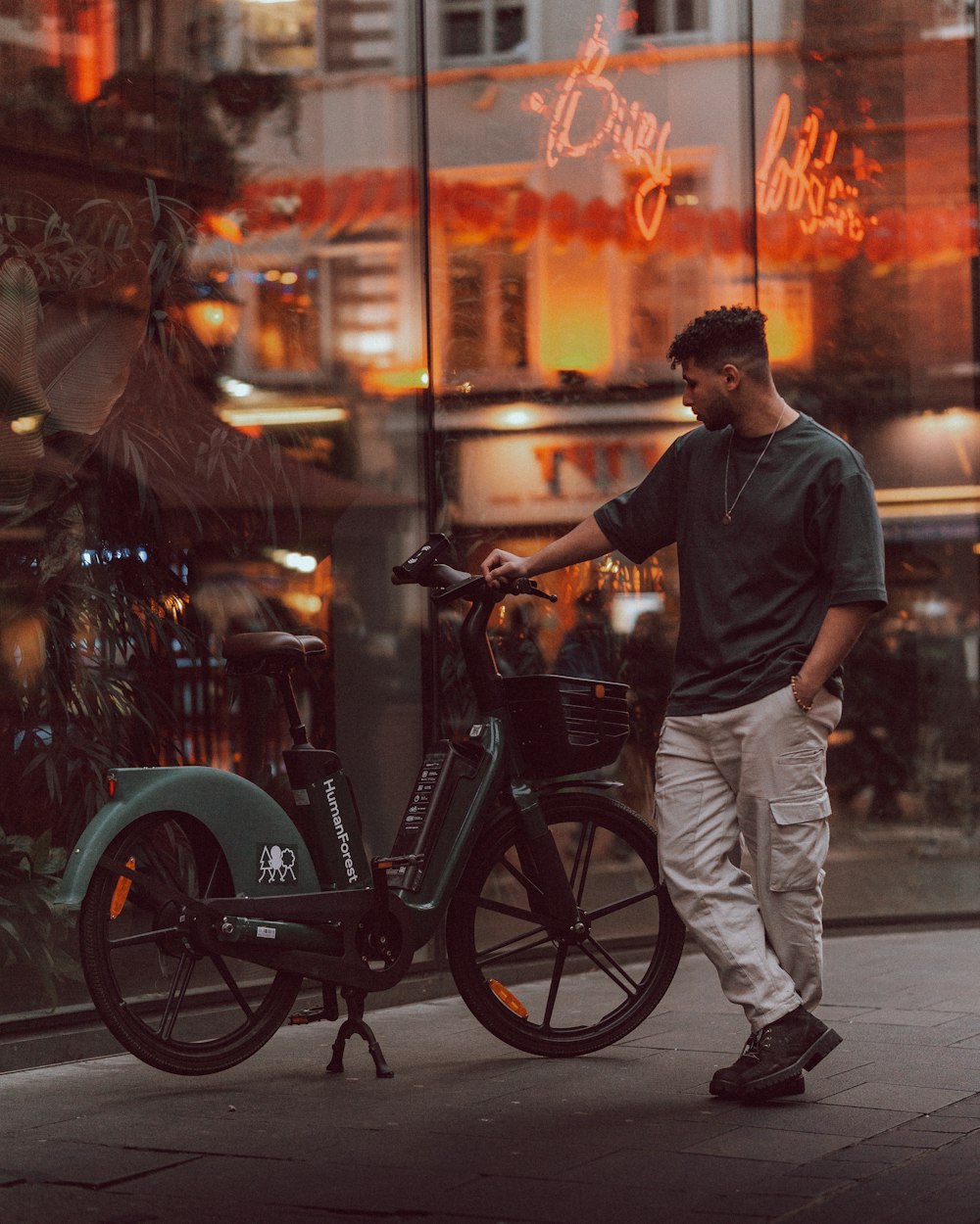 a man standing next to a bike on a city street