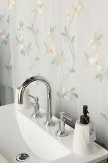 a white sink sitting under a bathroom mirror