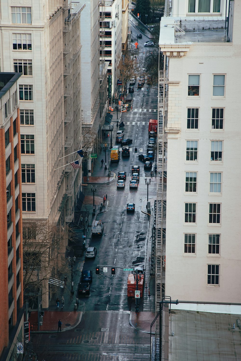 a city street filled with lots of traffic next to tall buildings