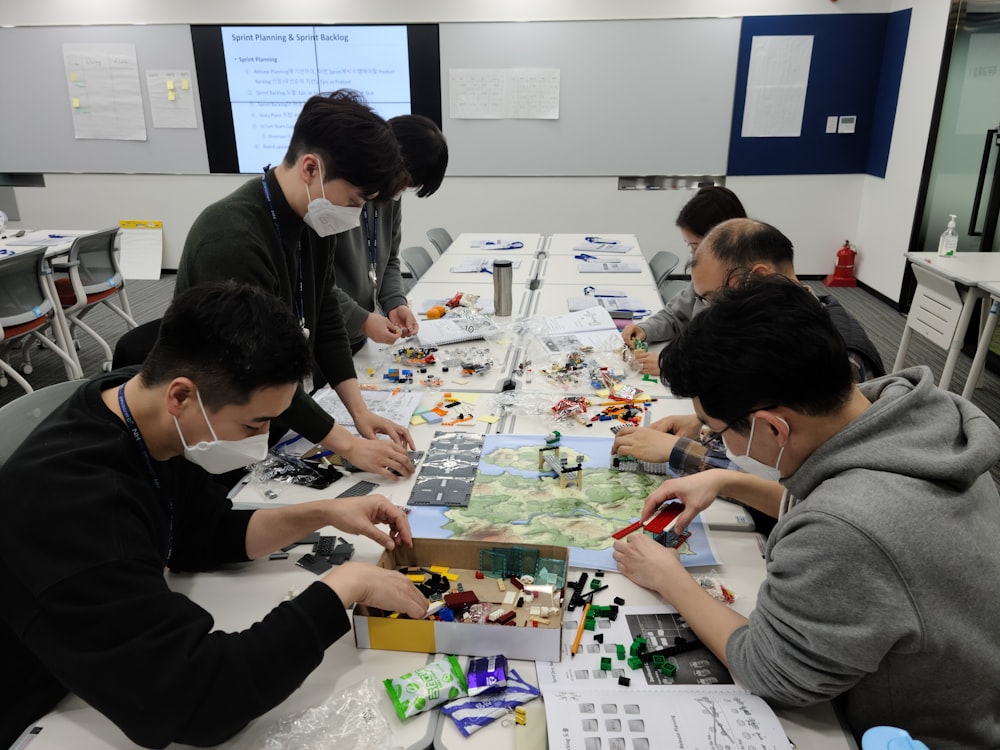 a group of people sitting around a table working on a project