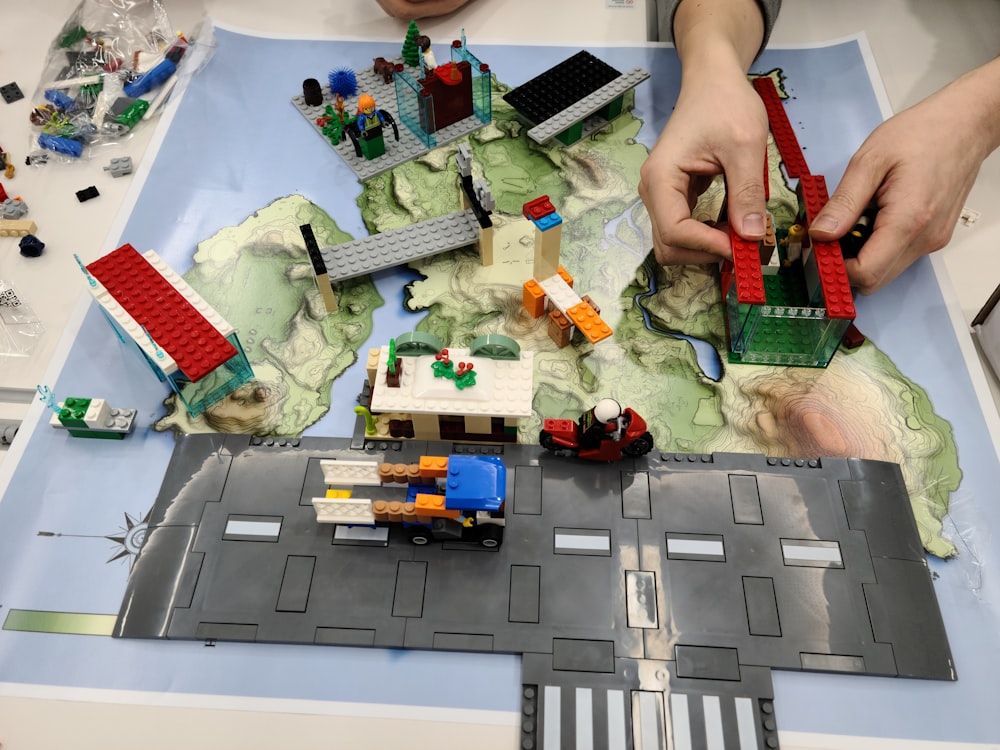 a child is playing with legos on a map