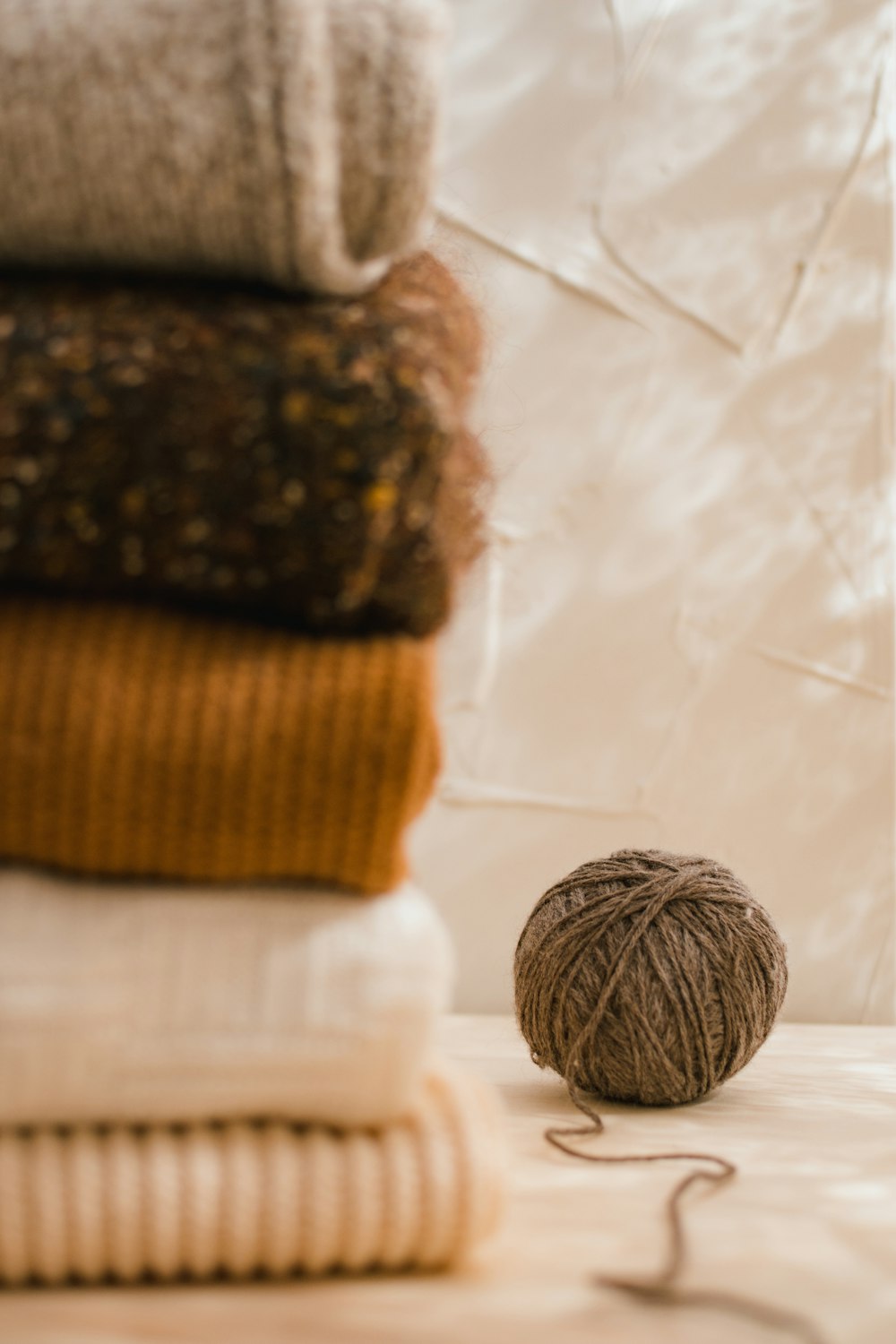 a ball of yarn sitting on top of a pile of blankets