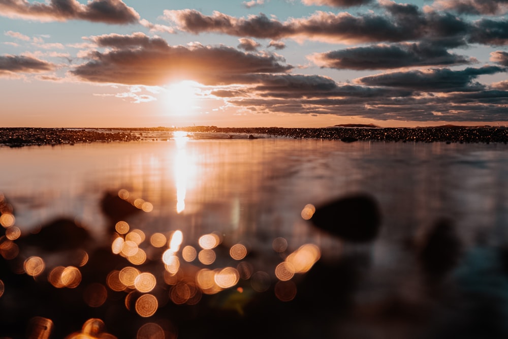 the sun is setting over a body of water