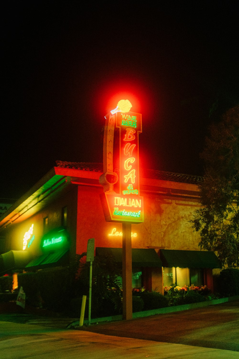 a neon sign is lit up in front of a restaurant