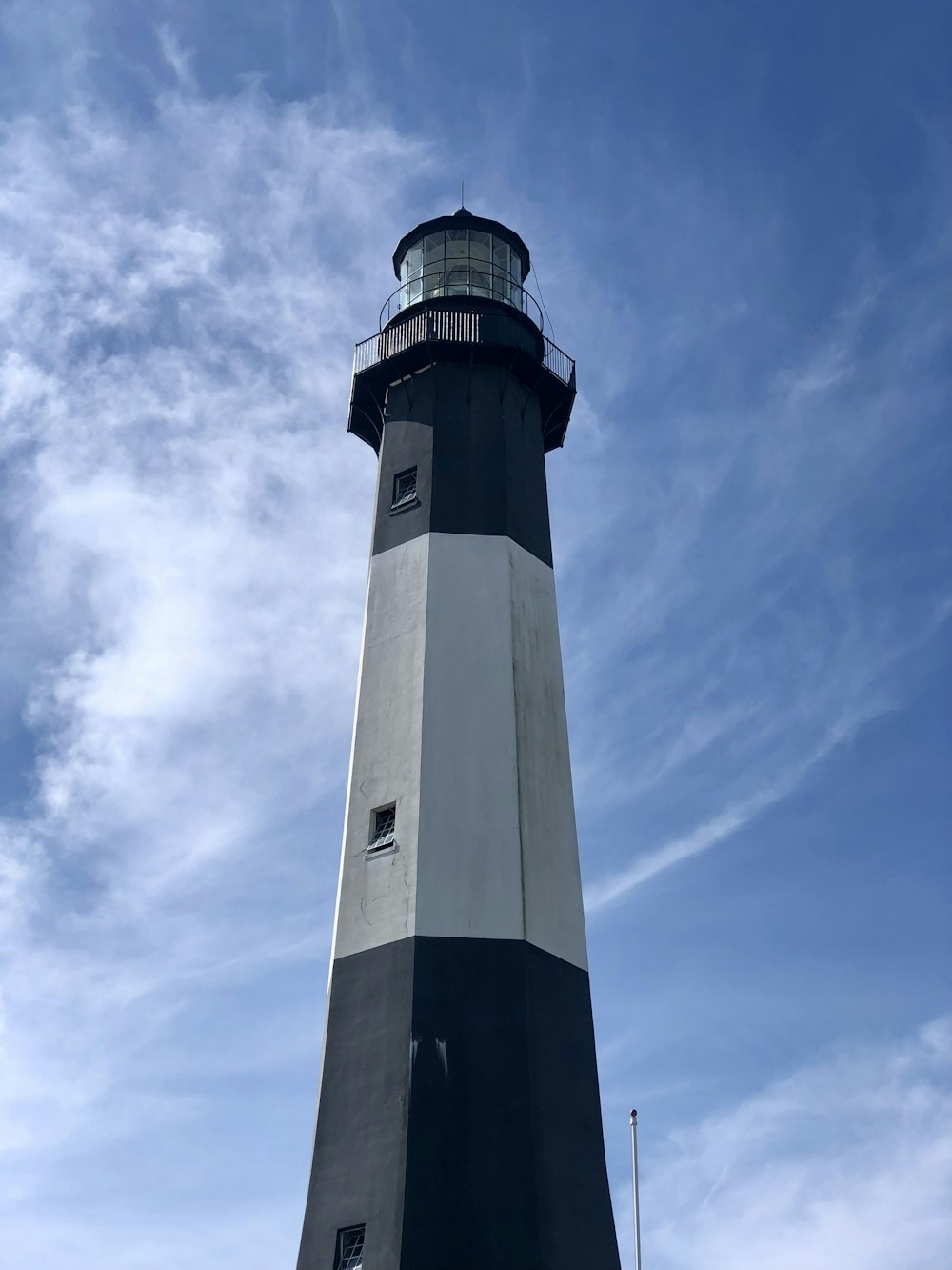 Un faro in bianco e nero sotto un cielo blu