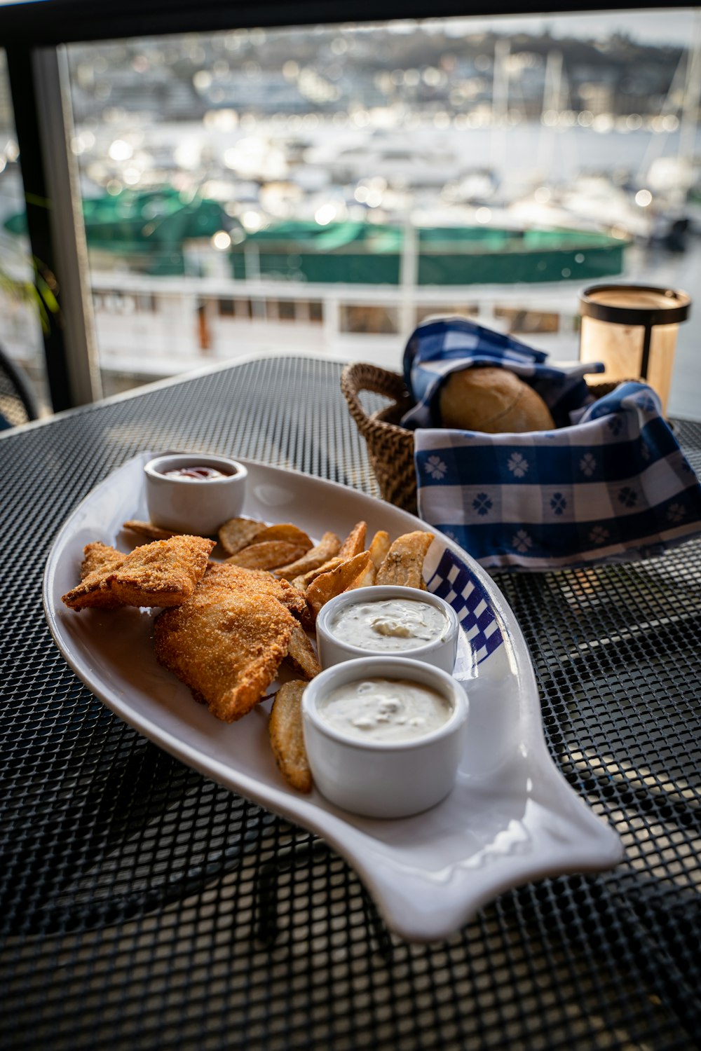 a plate of food on a table with a view of a harbor