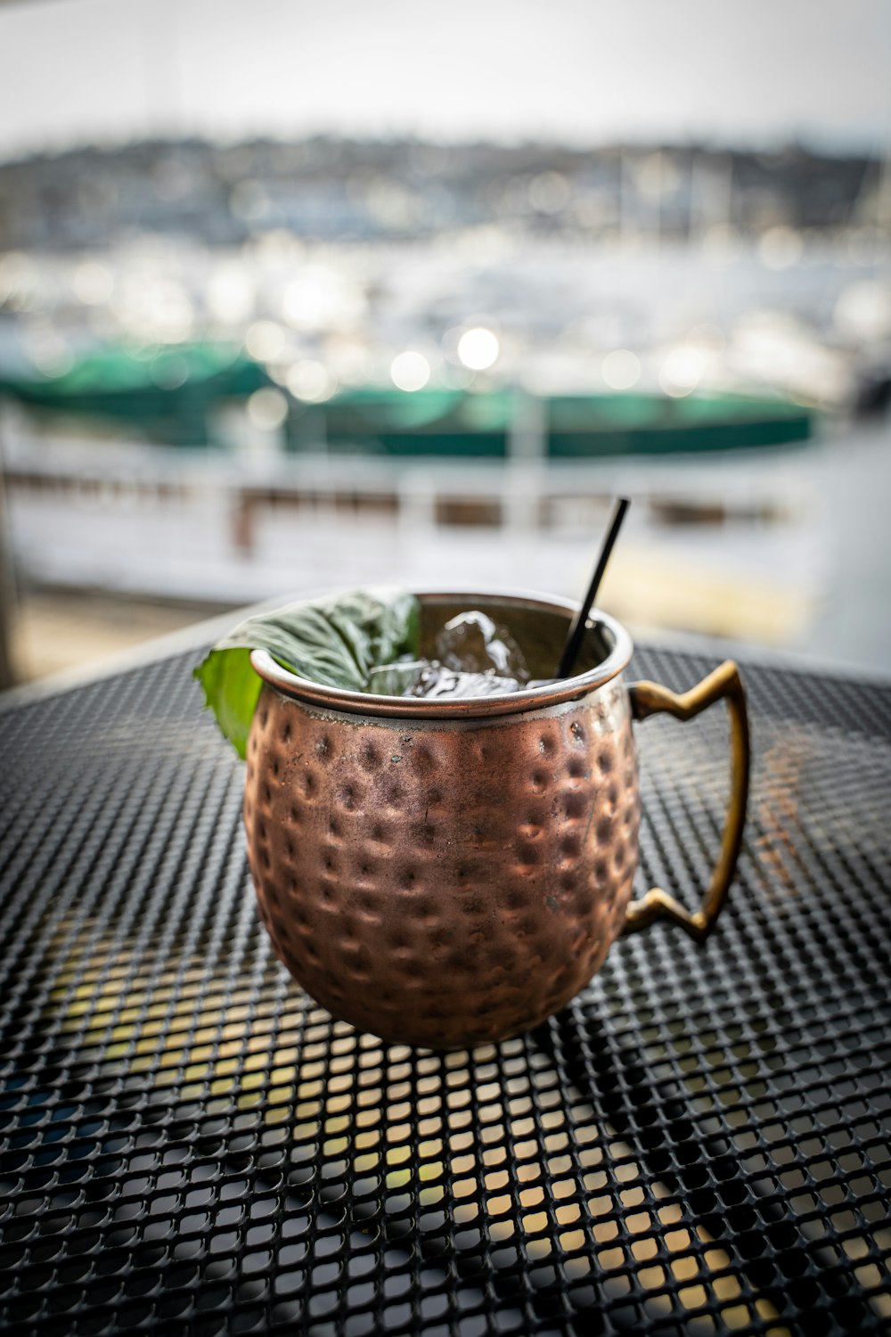 a metal cup with a drink in it on a table