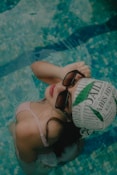 a woman in a bikini holding a ball in a swimming pool