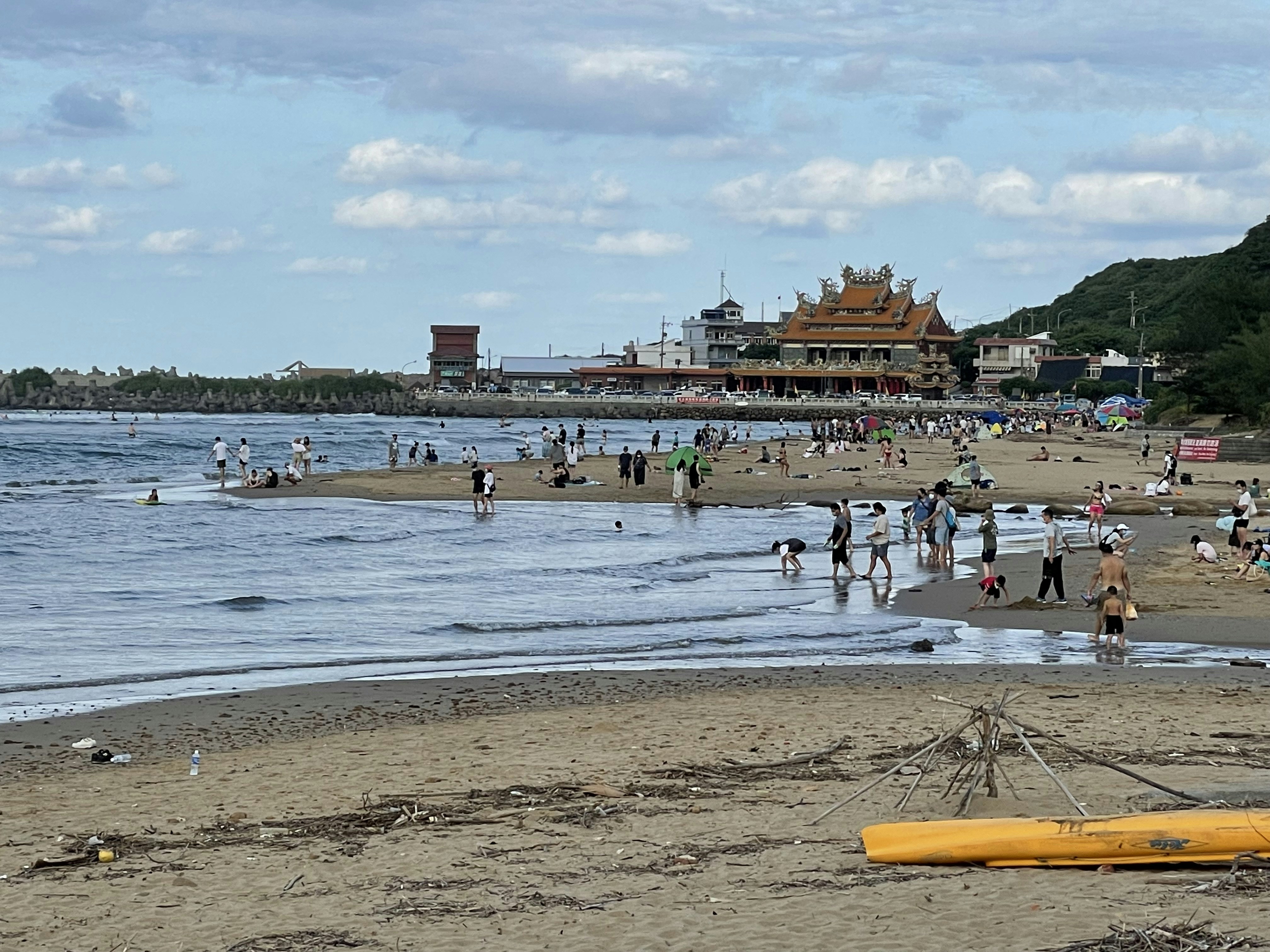 많은 사람들이 물 근처 해변에 있습니다.