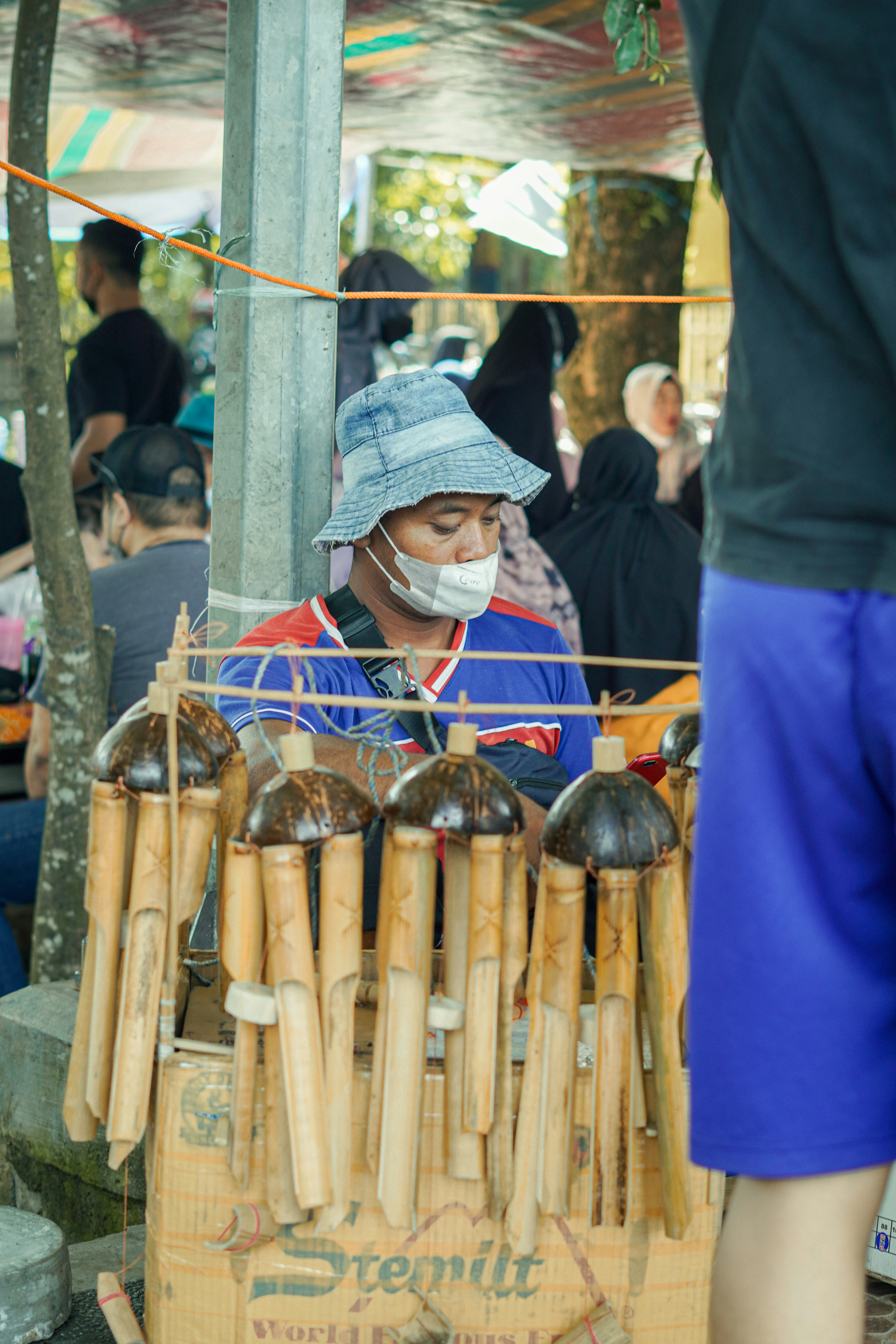a person wearing a face mask standing in front of a display of bottles