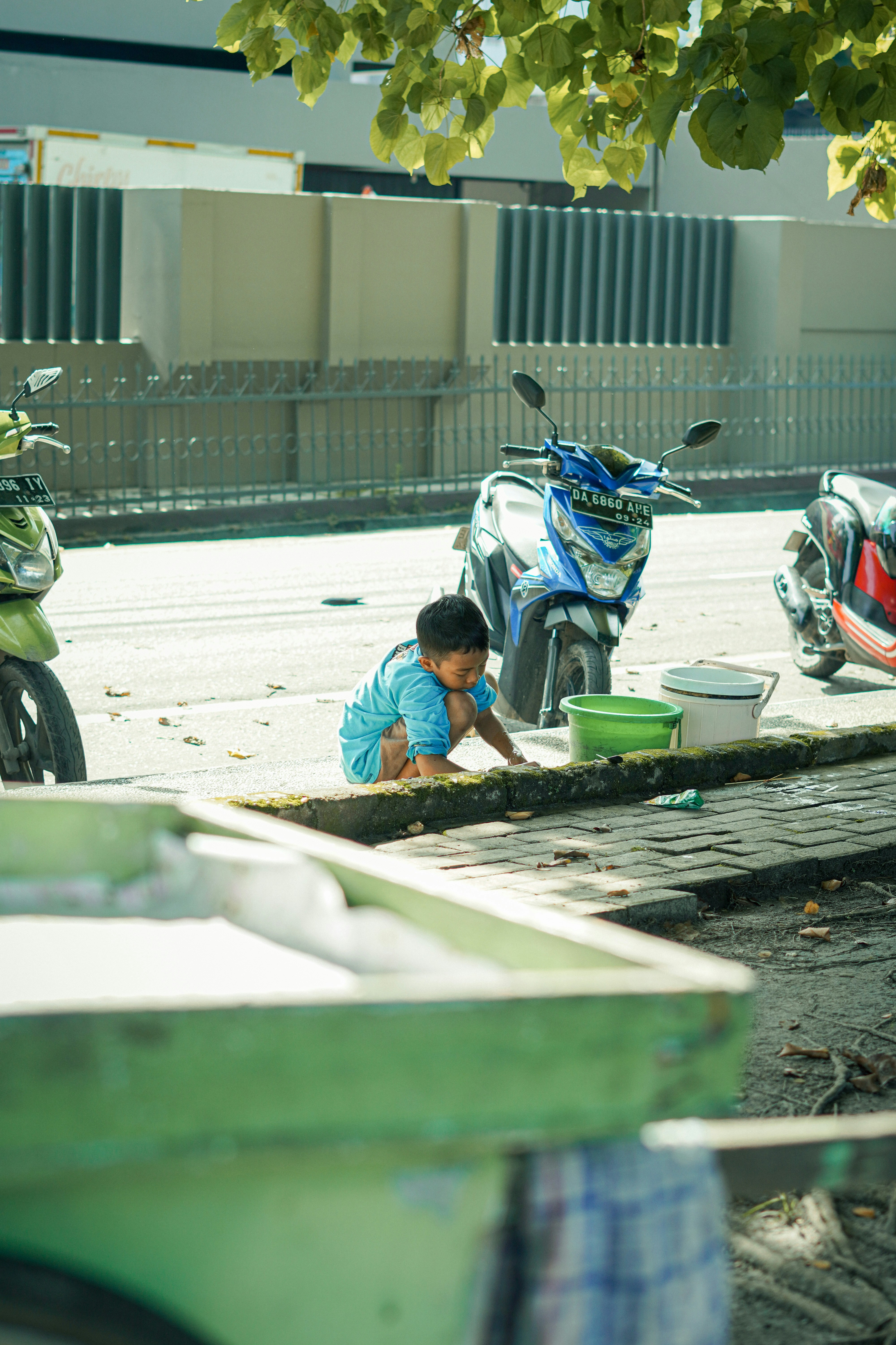 a young boy washing his hands on the ground