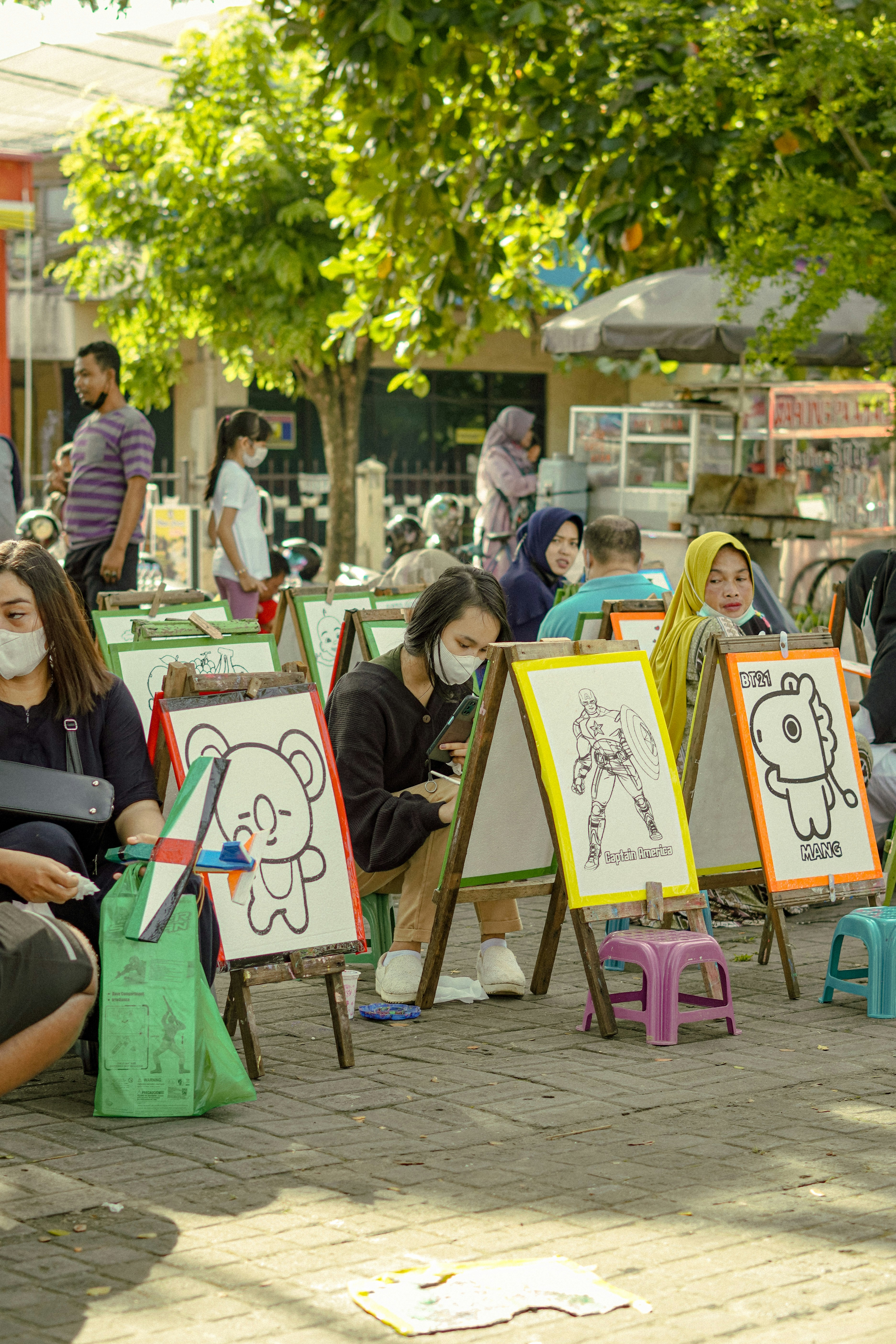 a group of people sitting next to each other in front of paintings