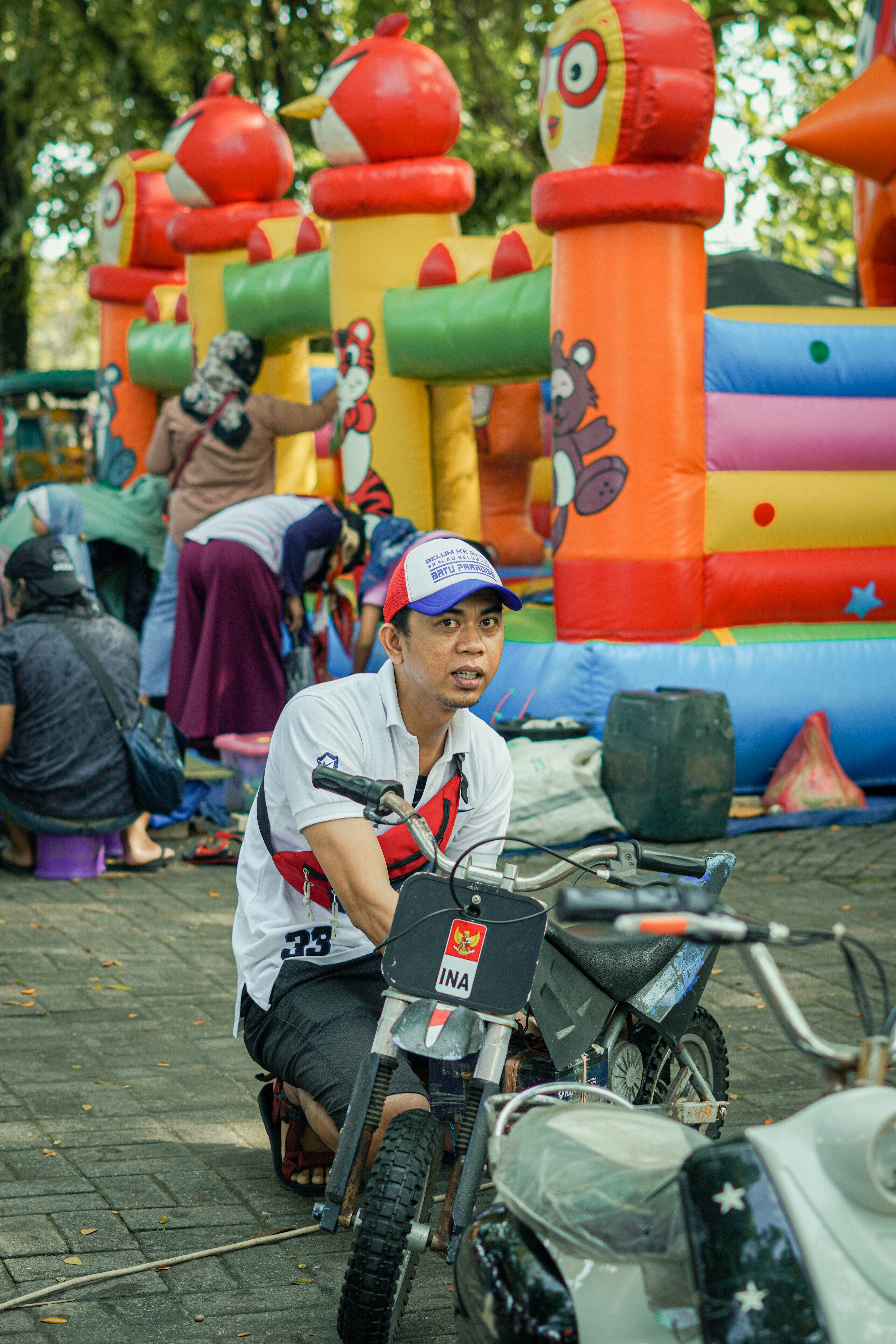 a man sitting on a motorcycle in front of a bunch of inflatables