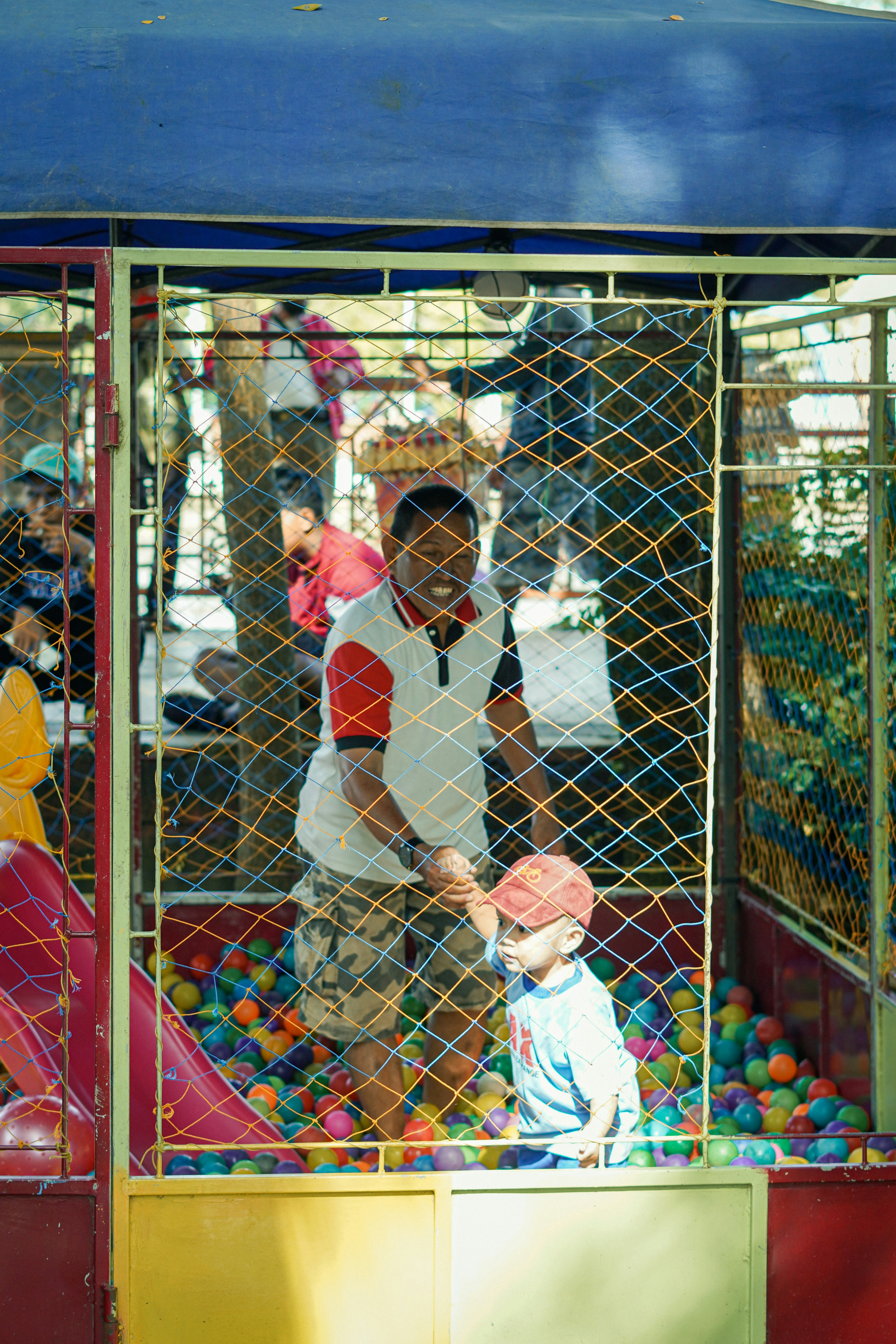 a man and a child playing in a ball pit