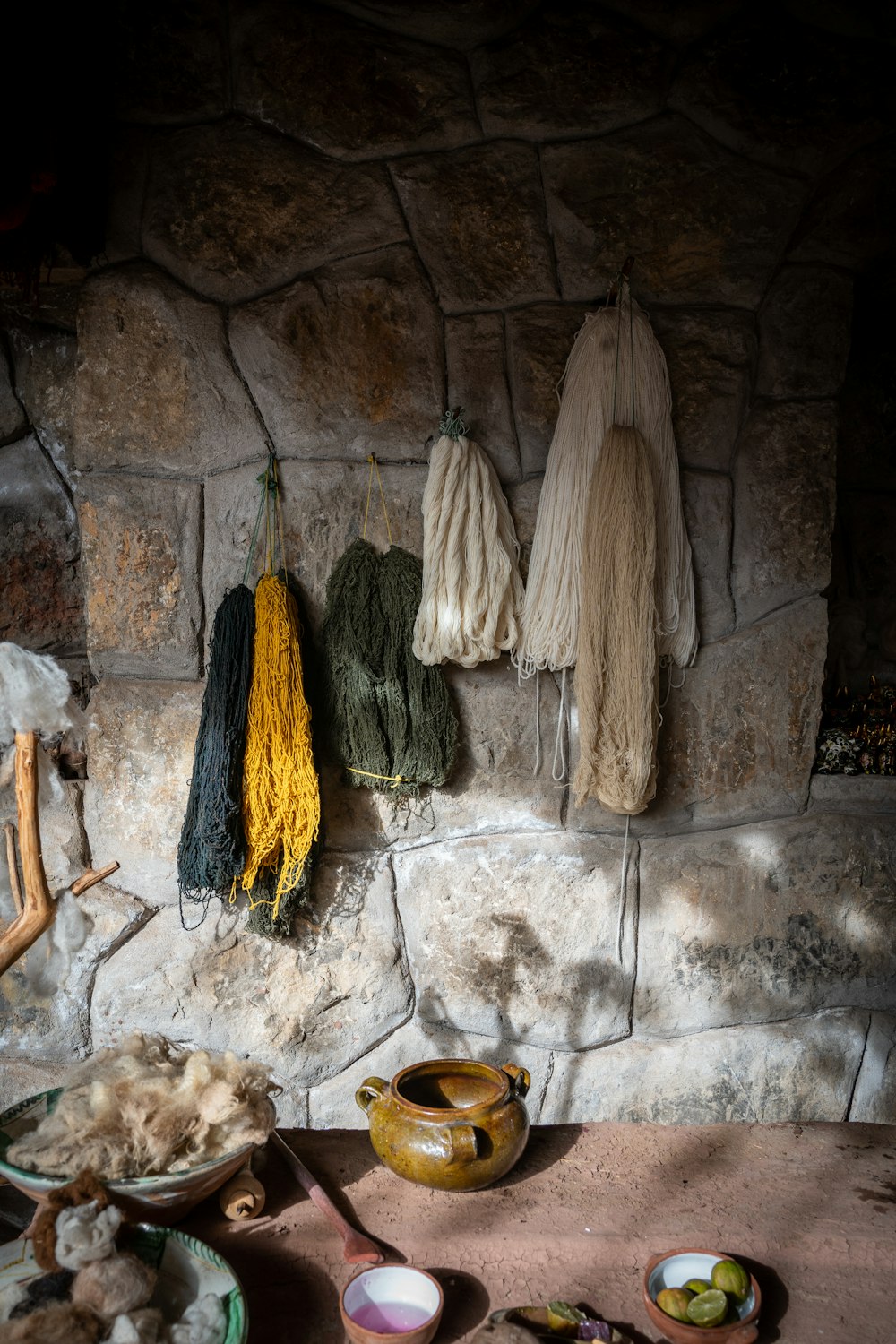 a stone wall with a bunch of yarn hanging on it