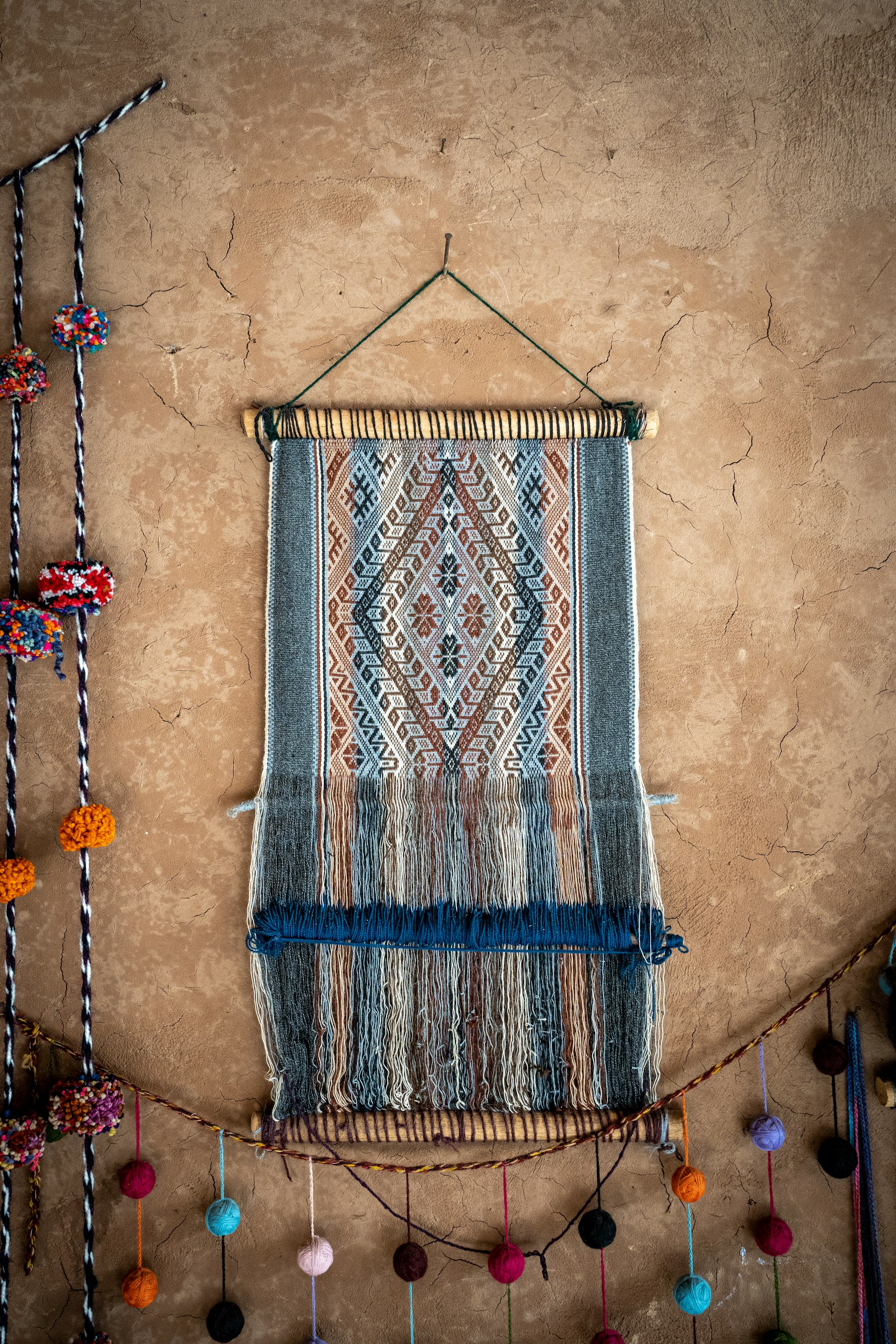 a wall hanging with a weaving on it