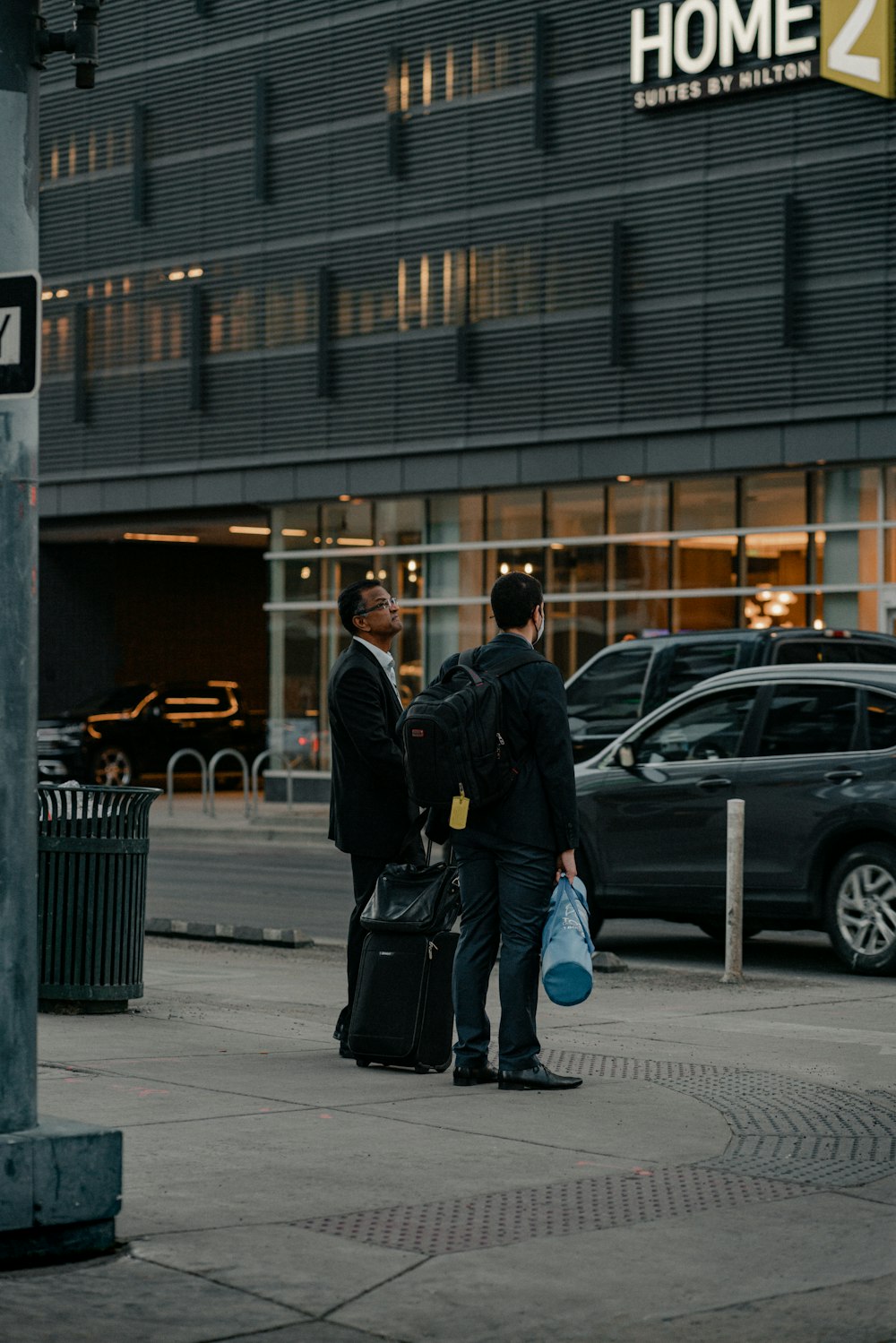 a couple of men standing next to each other on a sidewalk