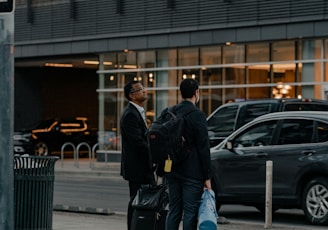 a couple of men standing next to each other on a sidewalk