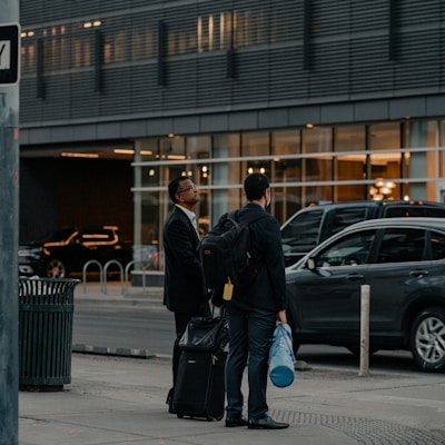 a couple of men standing next to each other on a sidewalk