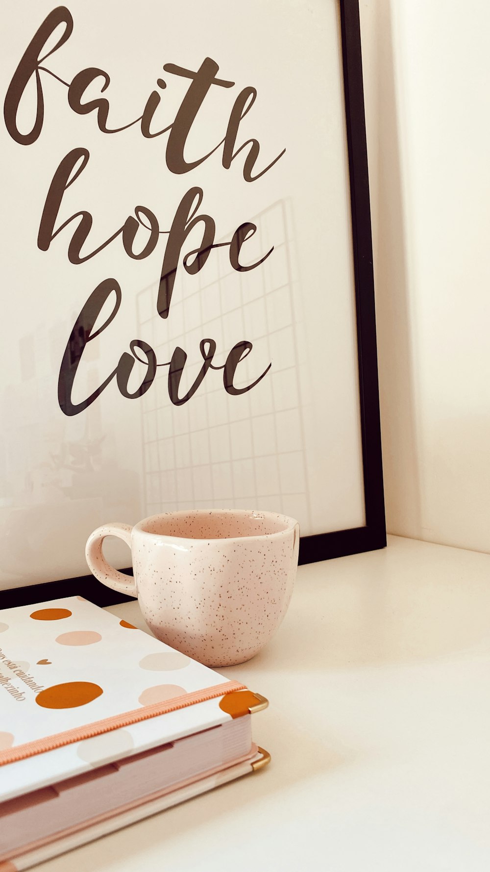 a cup of coffee sitting on top of a table next to a book