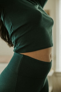a woman wearing a green top and leggings