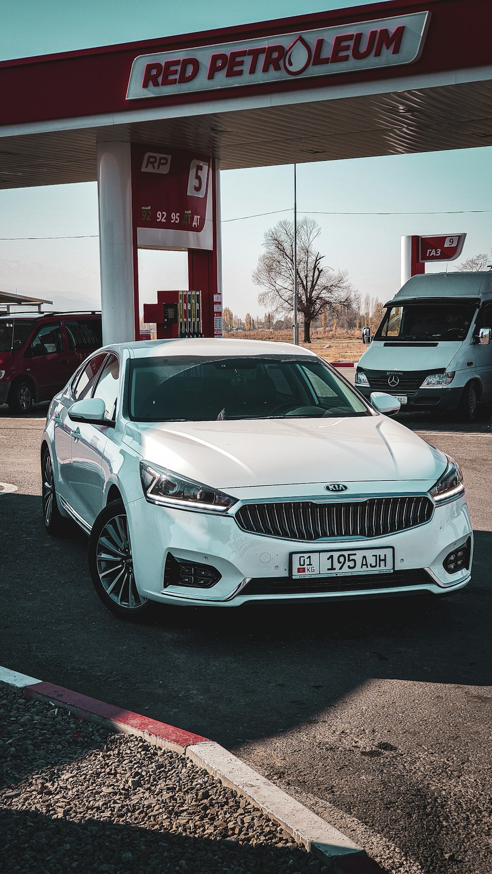 a white car parked in front of a gas station