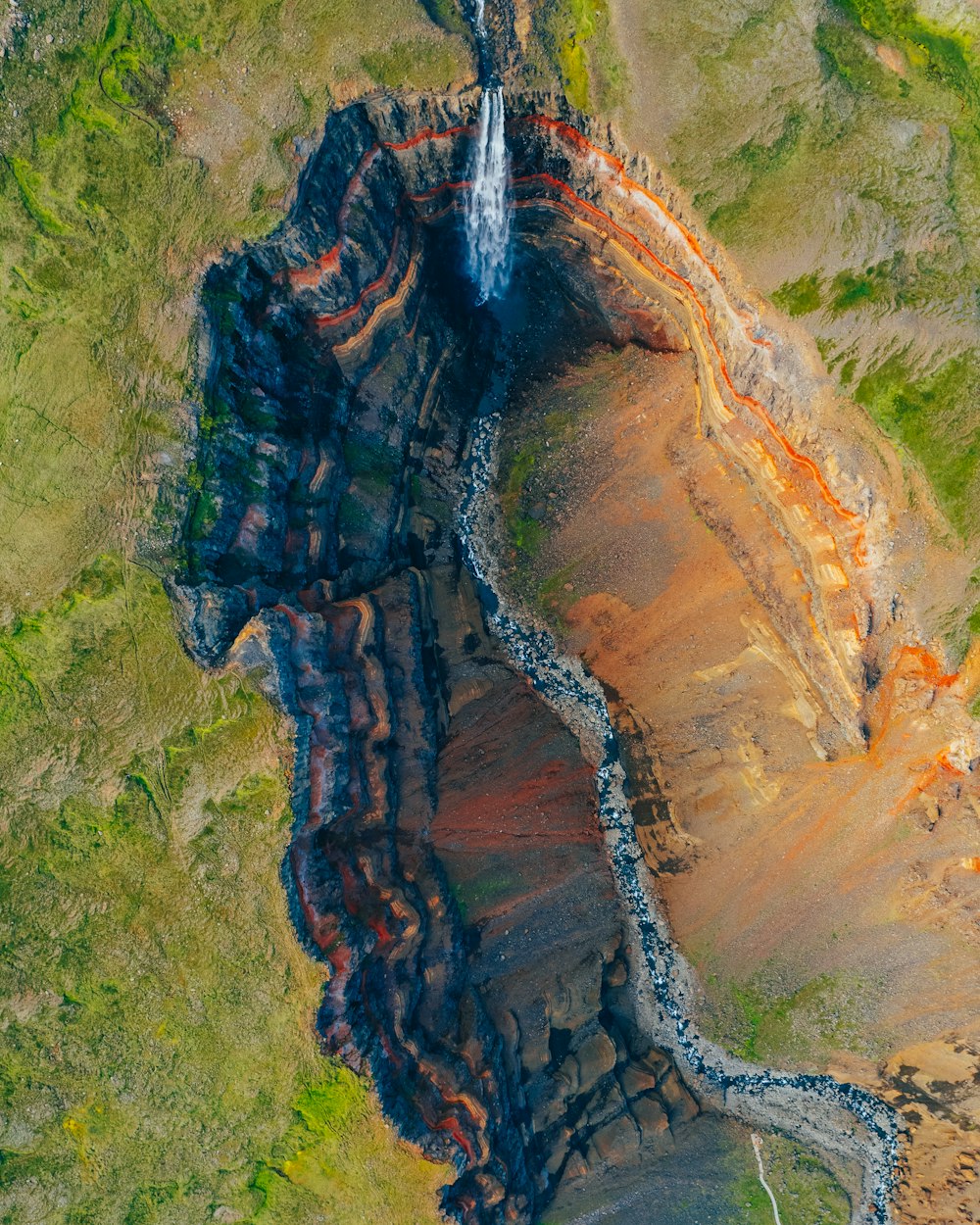 an aerial view of a waterfall in the mountains