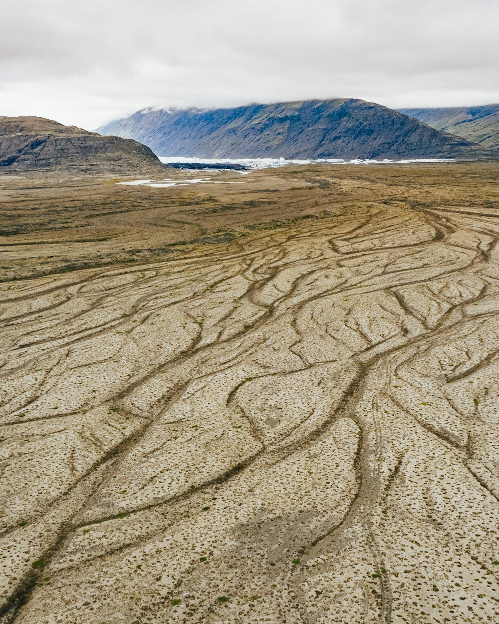 a dirt field with mountains in the background