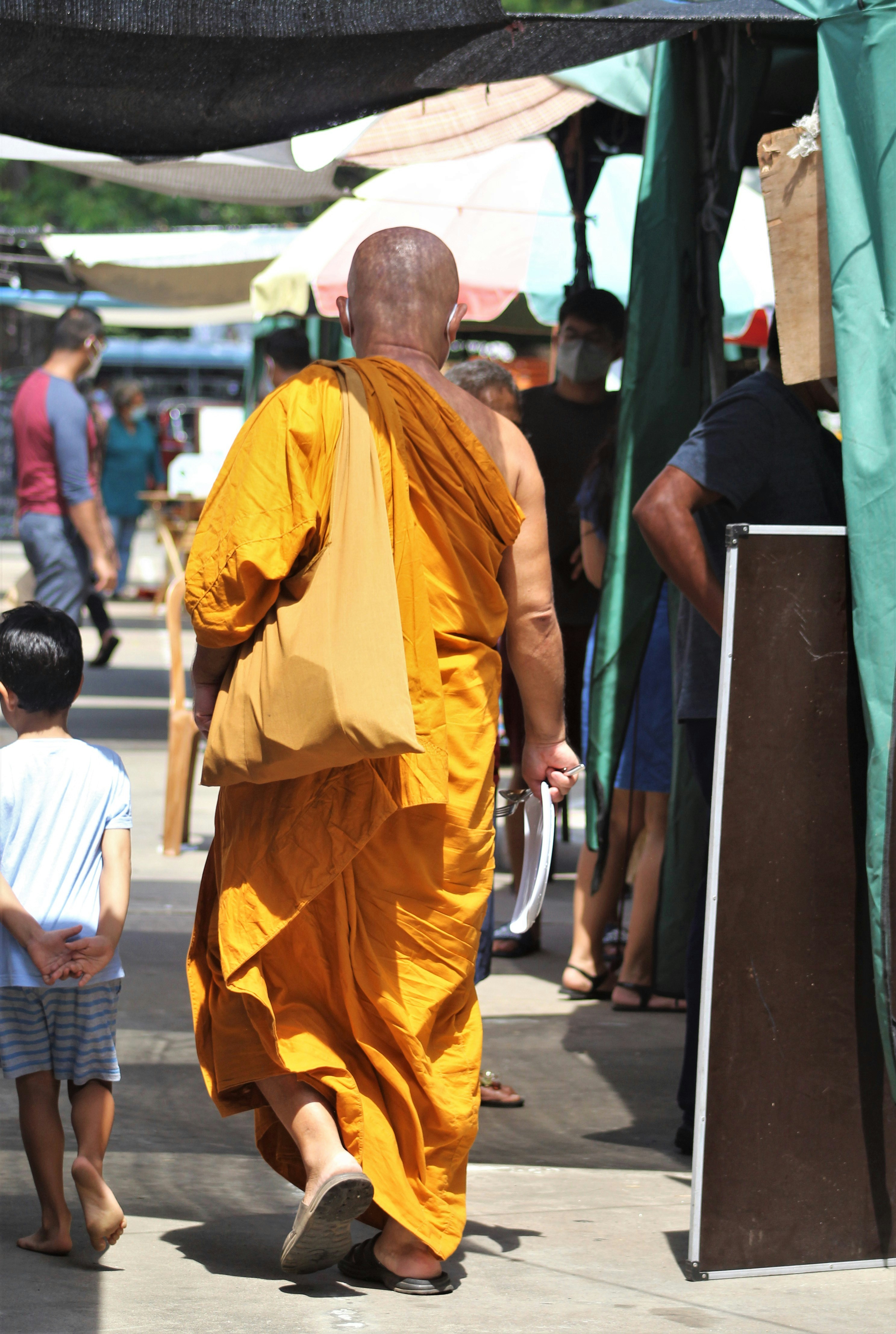 a man in a yellow robe walking down a street