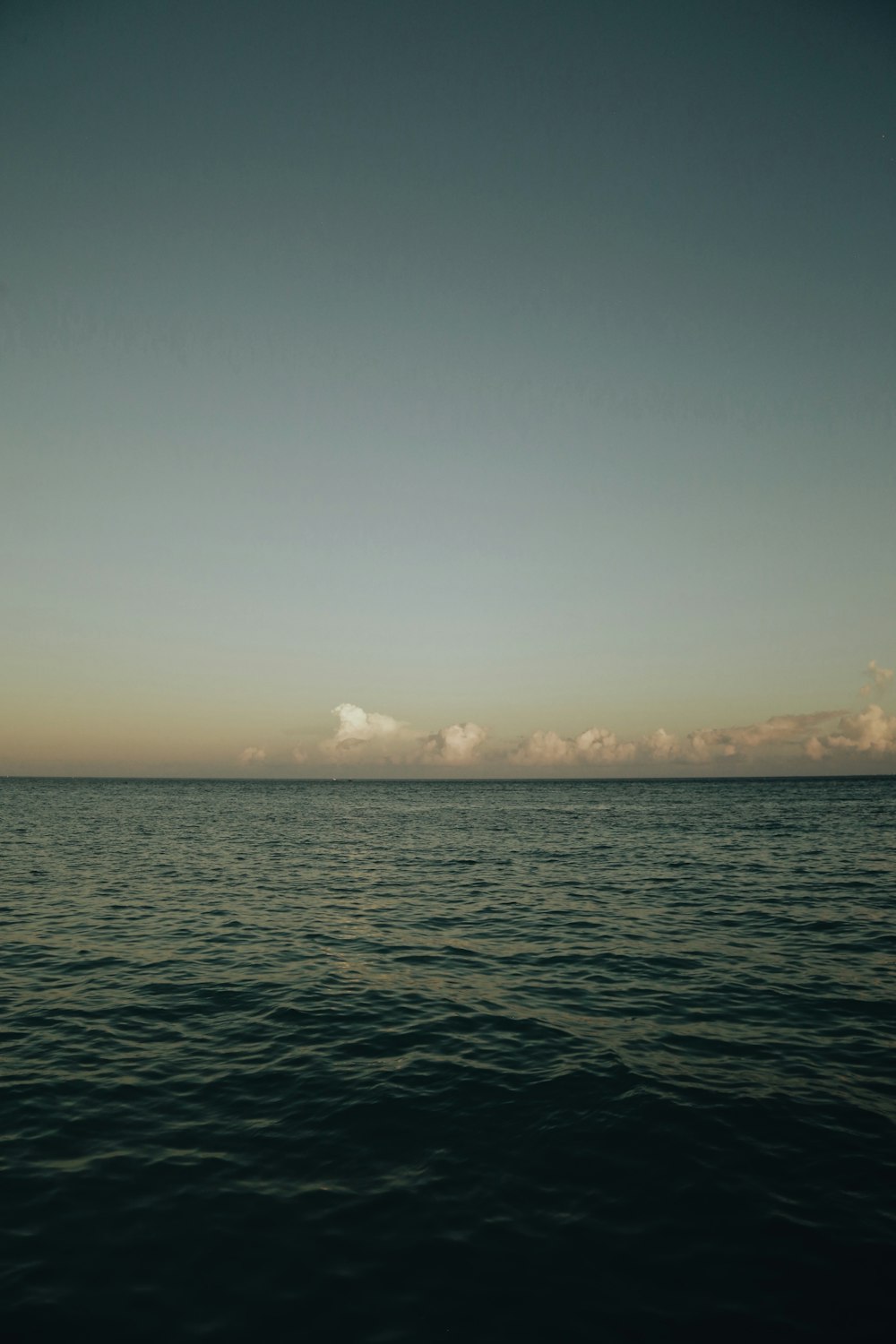 a large body of water sitting under a blue sky