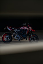 A sleek motorcycle shining under studio lights with red and black accents.