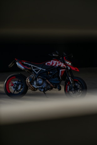 A sleek motorcycle shining under studio lights with red and black accents.