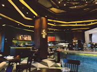 A modern cafe interior featuring glowing gold buttons on menu cards and cozy seating.