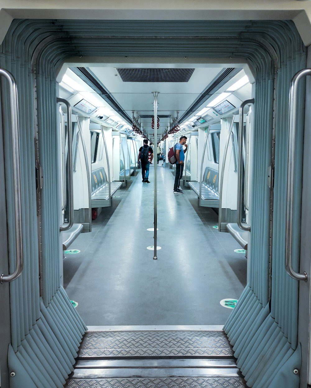 a subway car with people walking down it