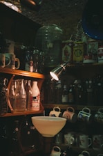 a kitchen with a sink and shelves full of bottles