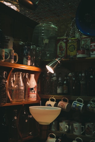 a kitchen with a sink and shelves full of bottles