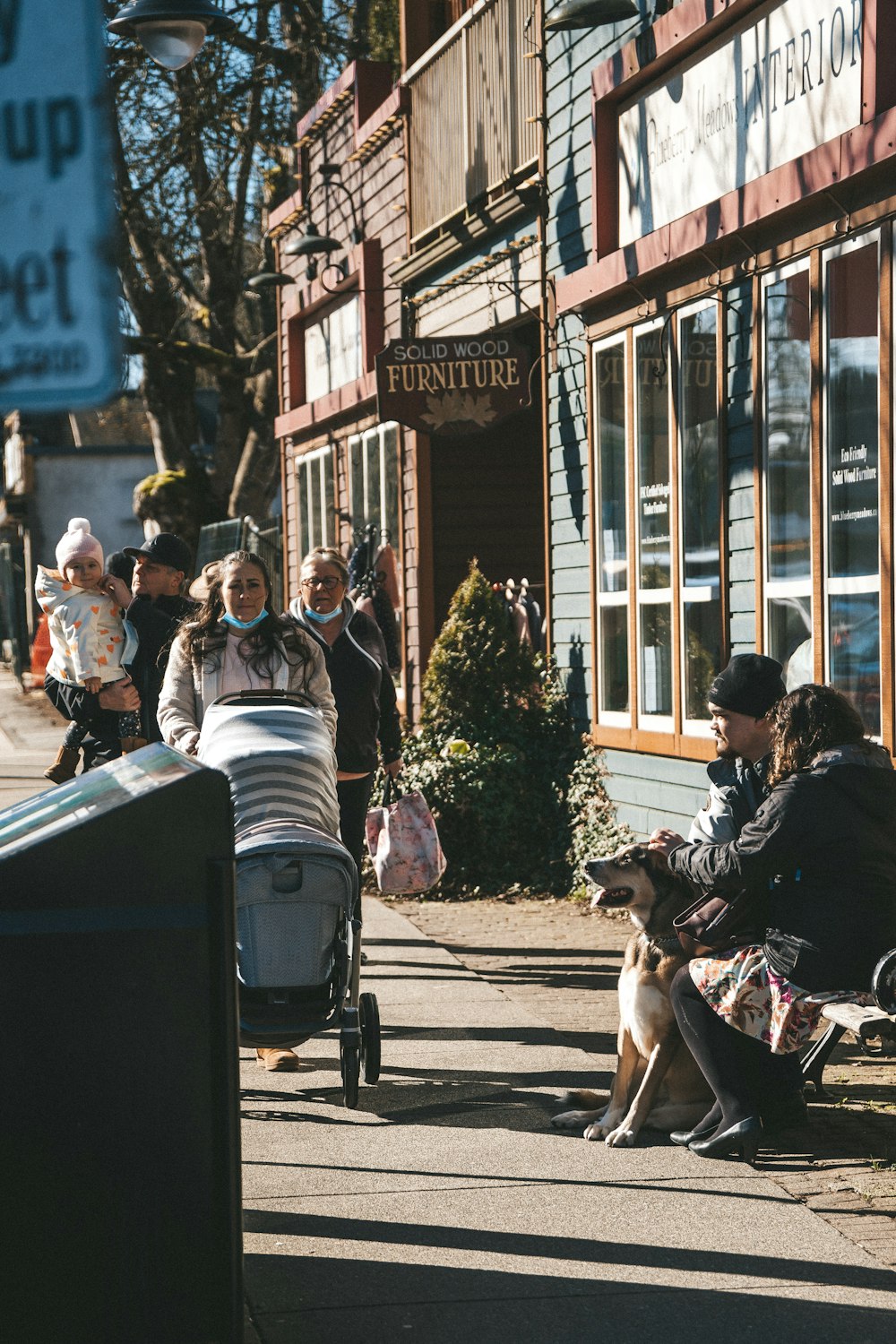 a woman sitting on a bench next to a baby carriage