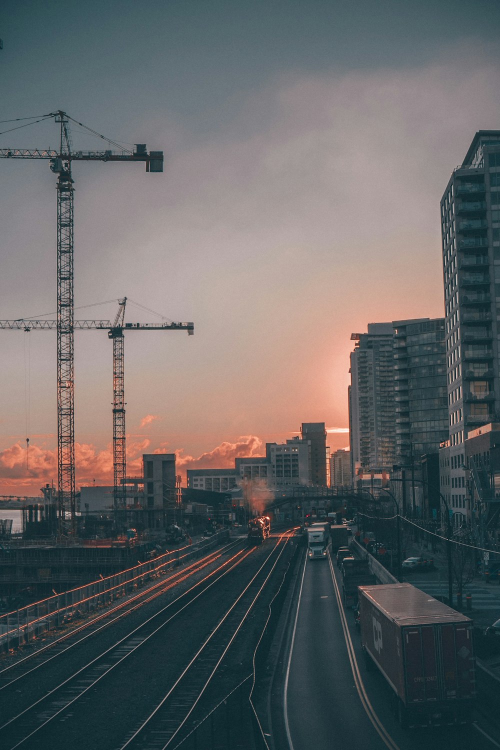 a train traveling down train tracks next to tall buildings