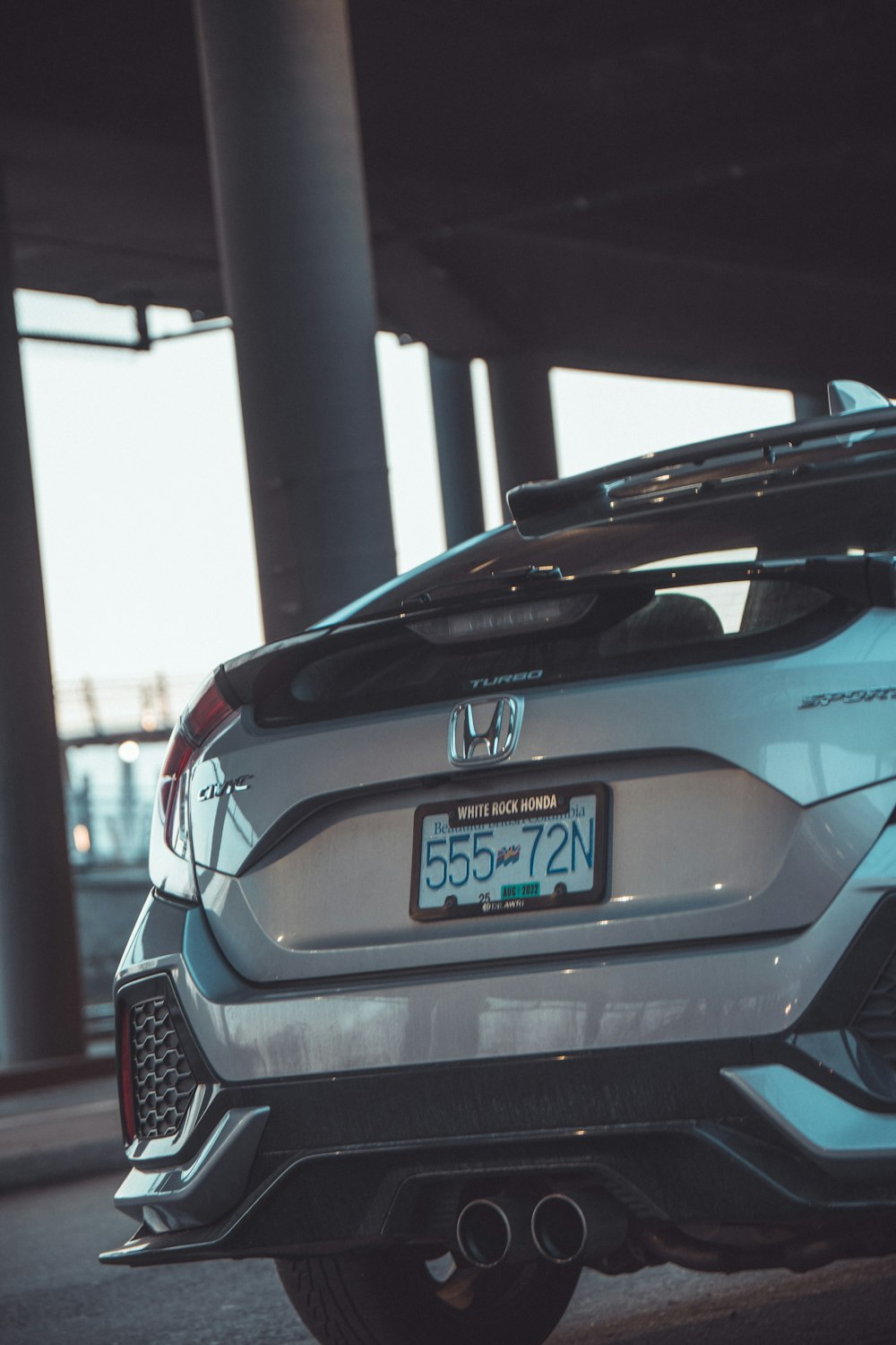 a white and blue car parked under a bridge