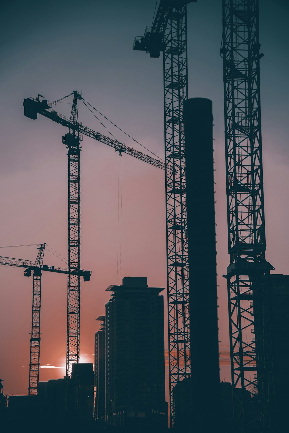 a group of cranes that are standing in the sky