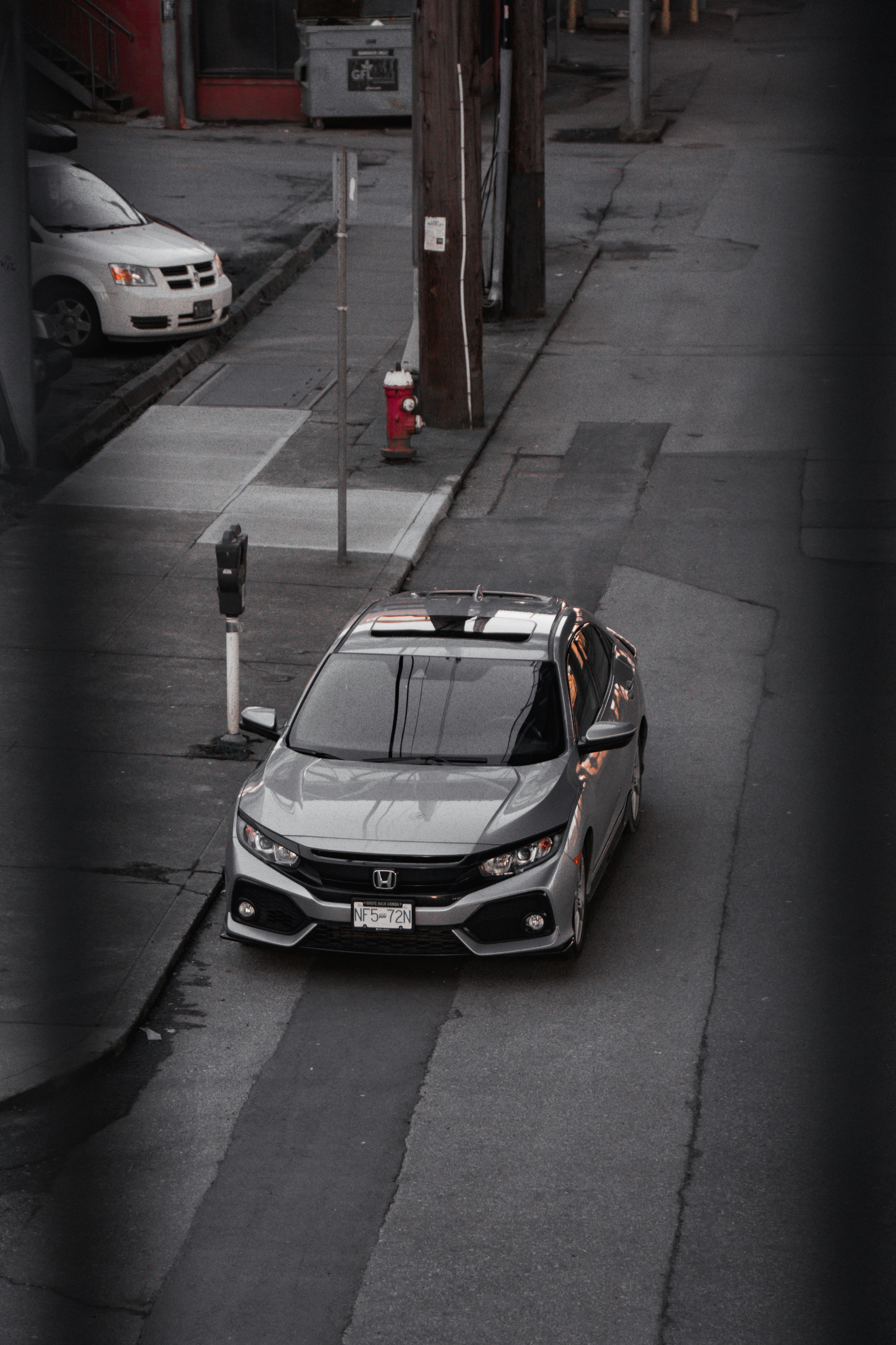 a car parked on the side of a road next to a parking meter